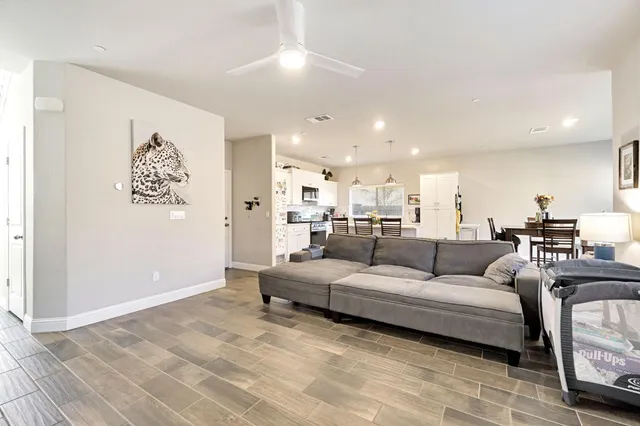 a living room with furniture and a view of kitchen