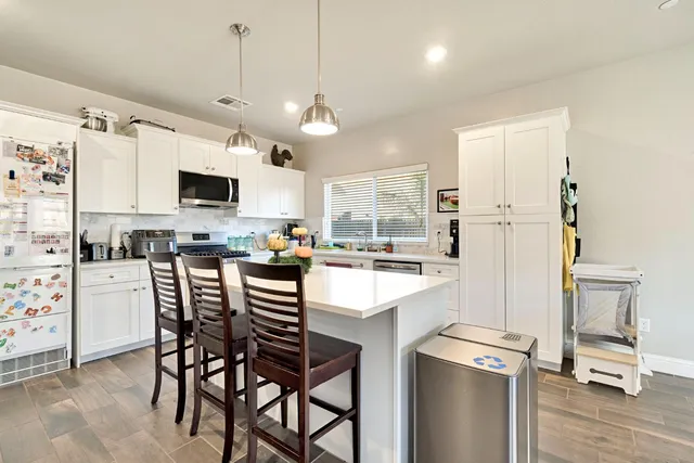 a kitchen with stainless steel appliances a stove a sink refrigerator and a microwave