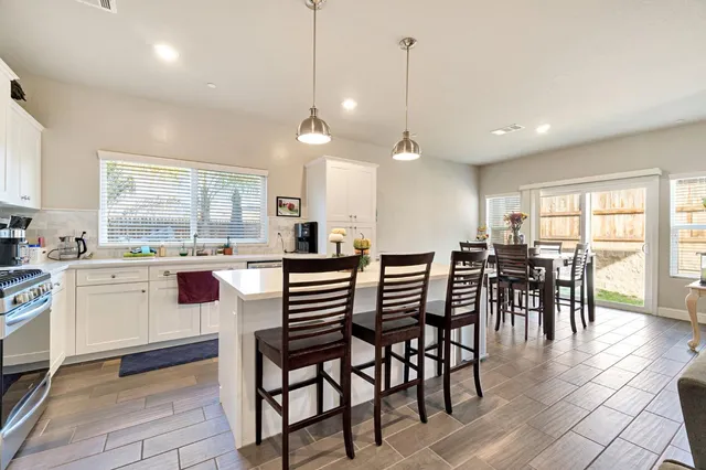 a kitchen with a table chairs stove and cabinets