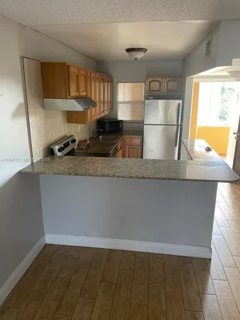 a view of a kitchen with wooden floor and a sink