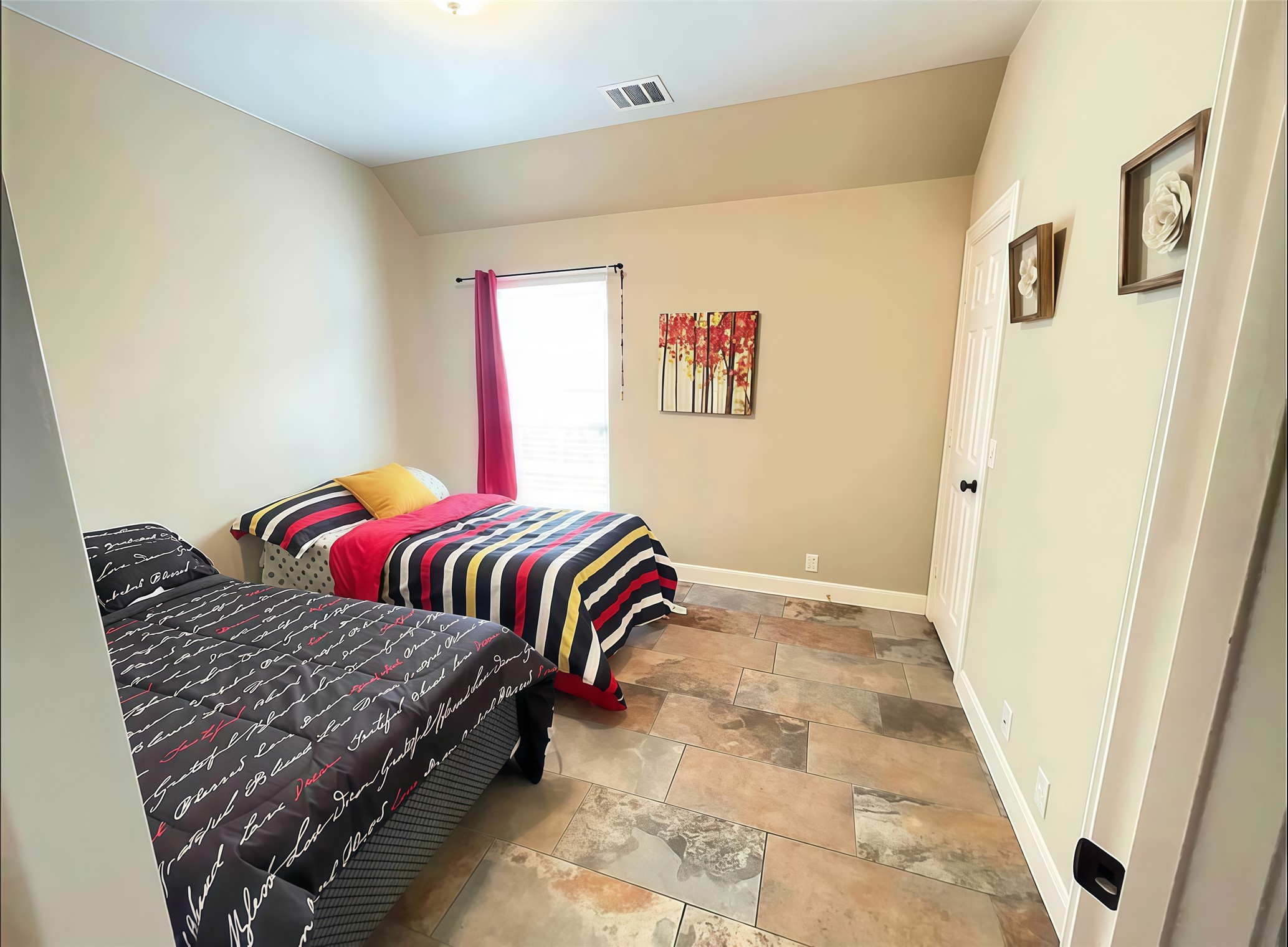 12616 Alberta Ridge Trail Austin, TX 78726 - Photo 20 of 26 Earthy tile flooring and vaulted ceilings define this comfortable secondary bedroom space.