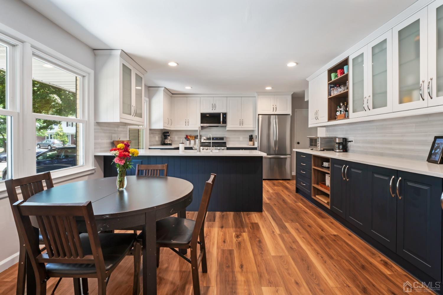 296 Colfax Road North Brunswick, NJ 08902 - Photo 15 of 37 a kitchen with stainless steel appliances granite countertop a sink a stove a kitchen island with chairs and wooden floor