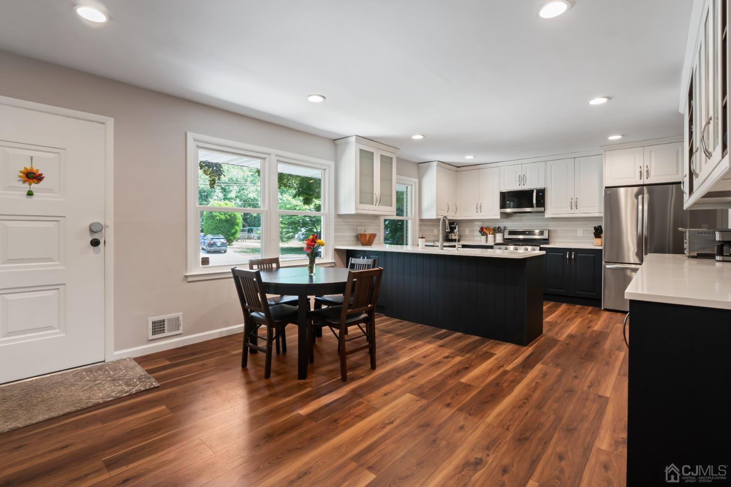 296 Colfax Road North Brunswick, NJ 08902 - Photo 8 of 37 a kitchen with stainless steel appliances granite countertop a stove a refrigerator a sink a dining table and chairs with wooden floor