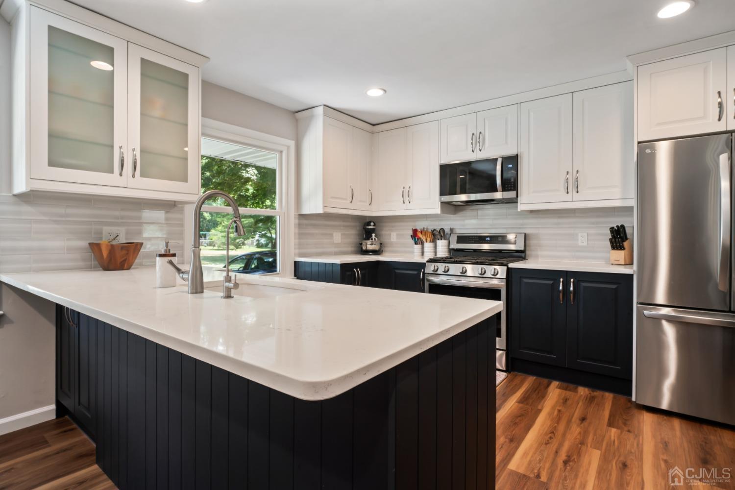 296 Colfax Road North Brunswick, NJ 08902 - Photo 10 of 37 a kitchen with a sink a counter top space stainless steel appliances a window and a refrigerator