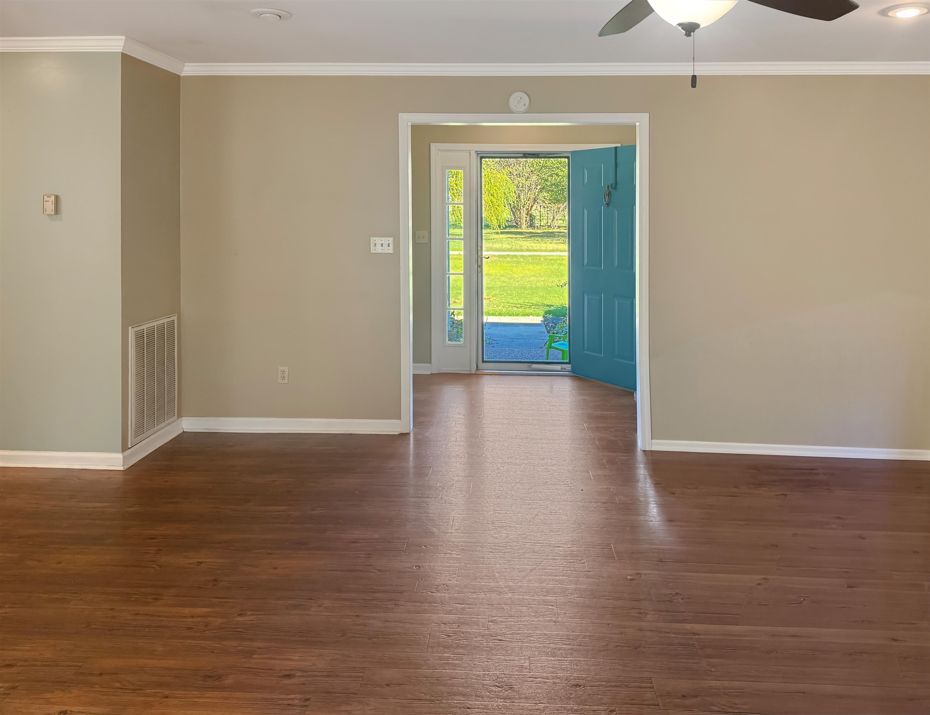 Spare room featuring ornamental molding, dark wood-style floors, and ceiling fan