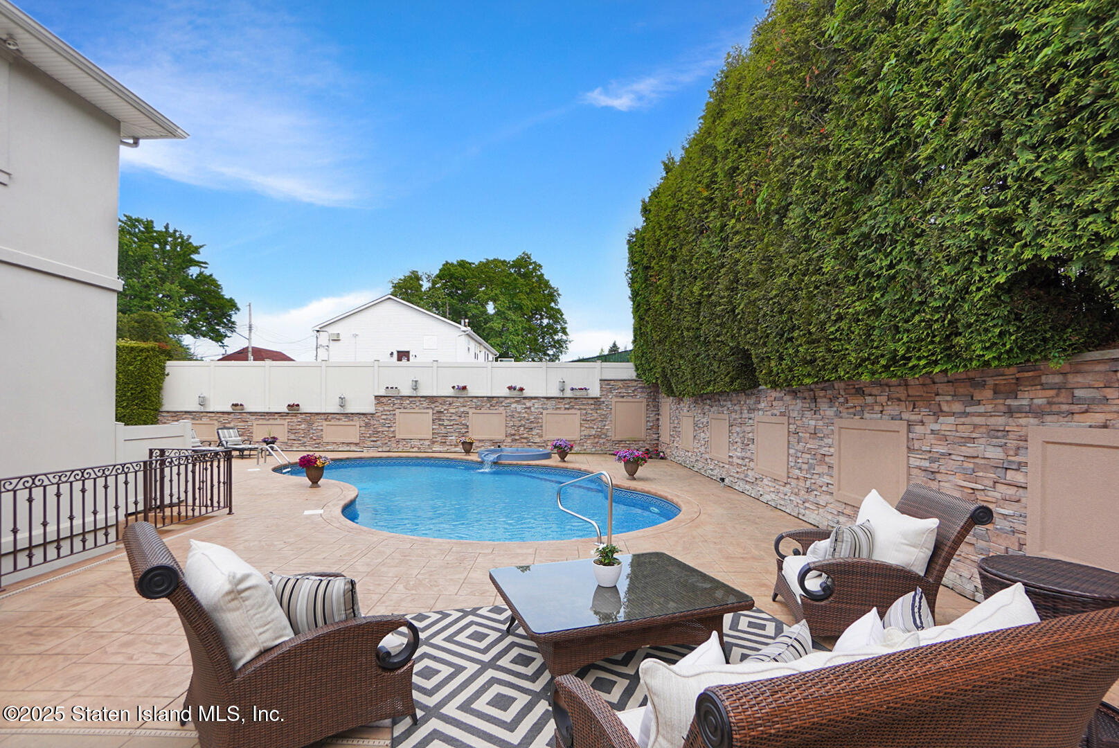 62 Ruxton Avenue Staten Island, NY 10312 - Photo 61 of 71 a view of a patio with couches table and chairs under an umbrella with a fire pit