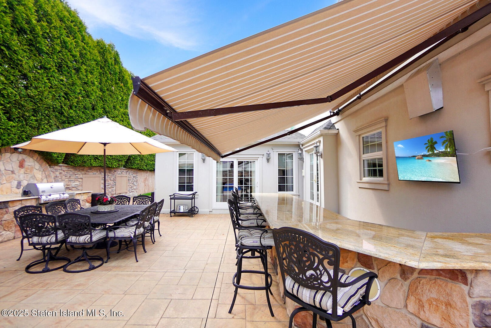 62 Ruxton Avenue Staten Island, NY 10312 - Photo 64 of 71 a view of a patio with table and chairs under an umbrella