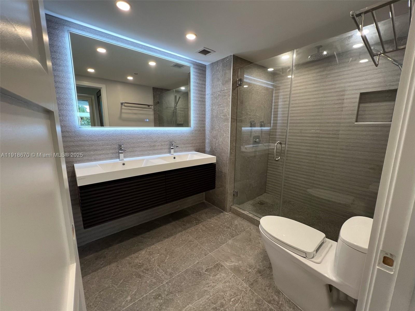 200 Ocean Drive, Unit 3C Miami Beach, FL 33139 - Photo 12 of 12 a bathroom with a double vanity sink toilet and shower