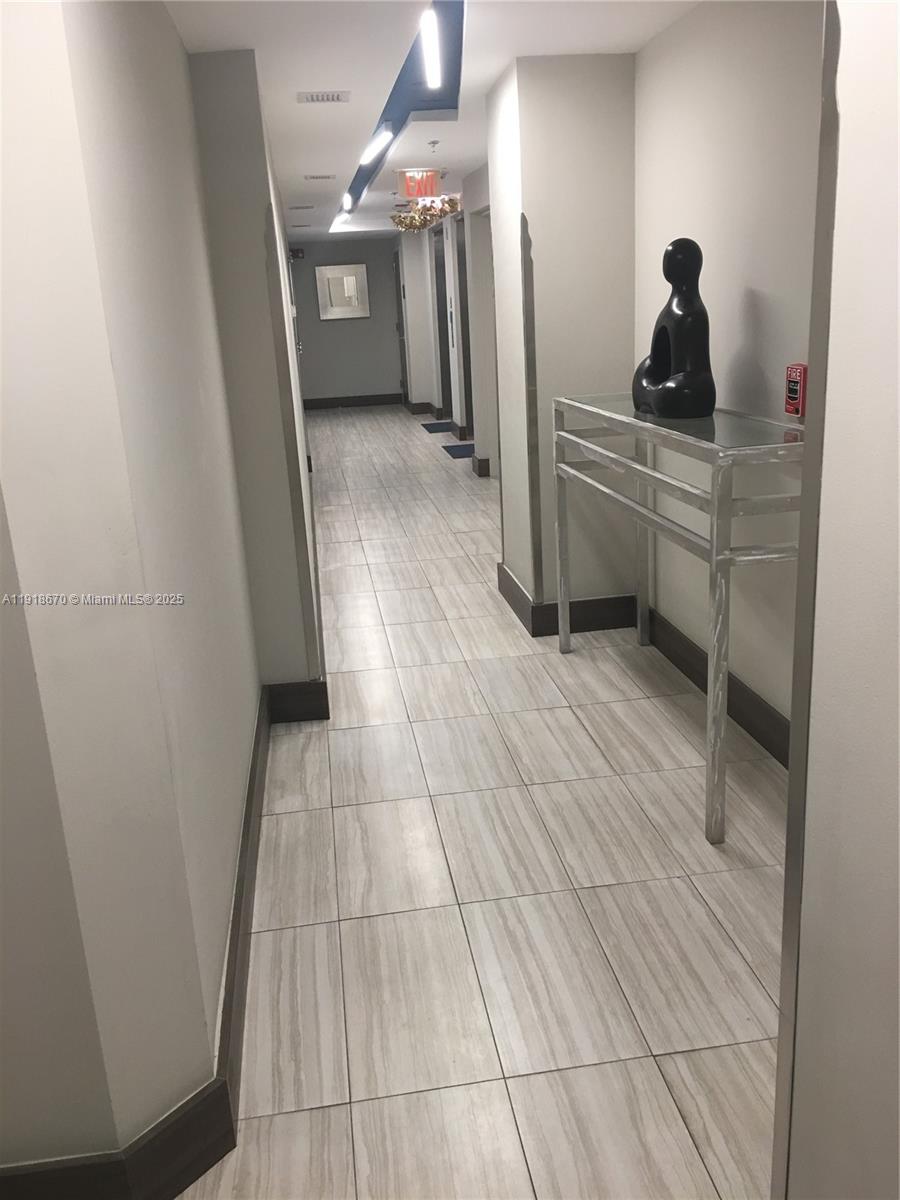 200 Ocean Drive, Unit 3C Miami Beach, FL 33139 - Photo 6 of 12 a hallway view with wooden floor and staircase