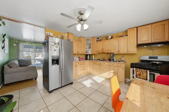 a kitchen with stainless steel appliances granite countertop a refrigerator a sink a stove and white cabinets