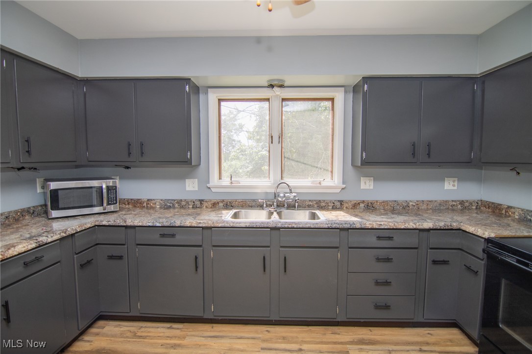 70973 Morristown Flushing Road Flushing, OH 43977 - Photo 5 of 44 Kitchen with gray cabinets, black electric range oven, stainless steel microwave, and light wood-style flooring