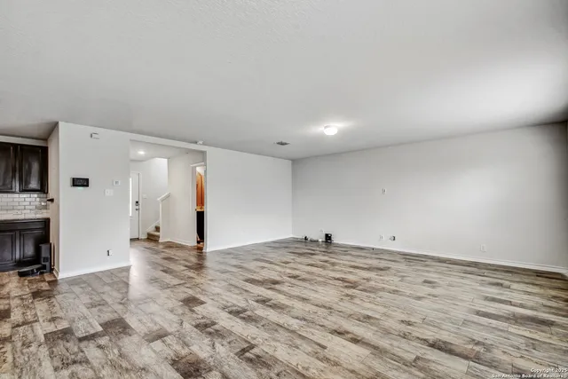 a view of empty room with kitchen