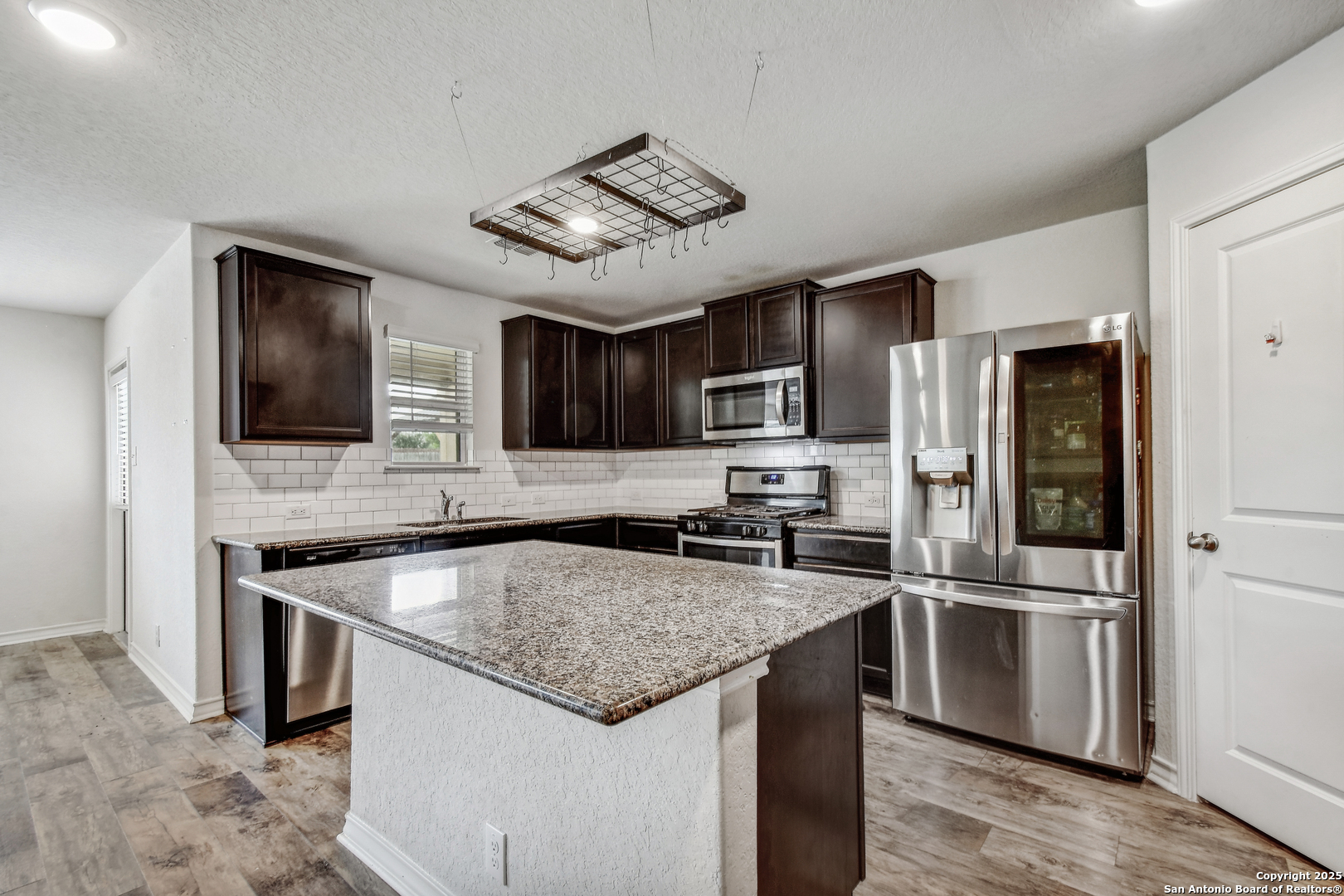 9627 Baytown Coast San Antonio, TX 78254 - Photo 8 of 22 a kitchen with stainless steel appliances granite countertop a sink stove microwave and refrigerator