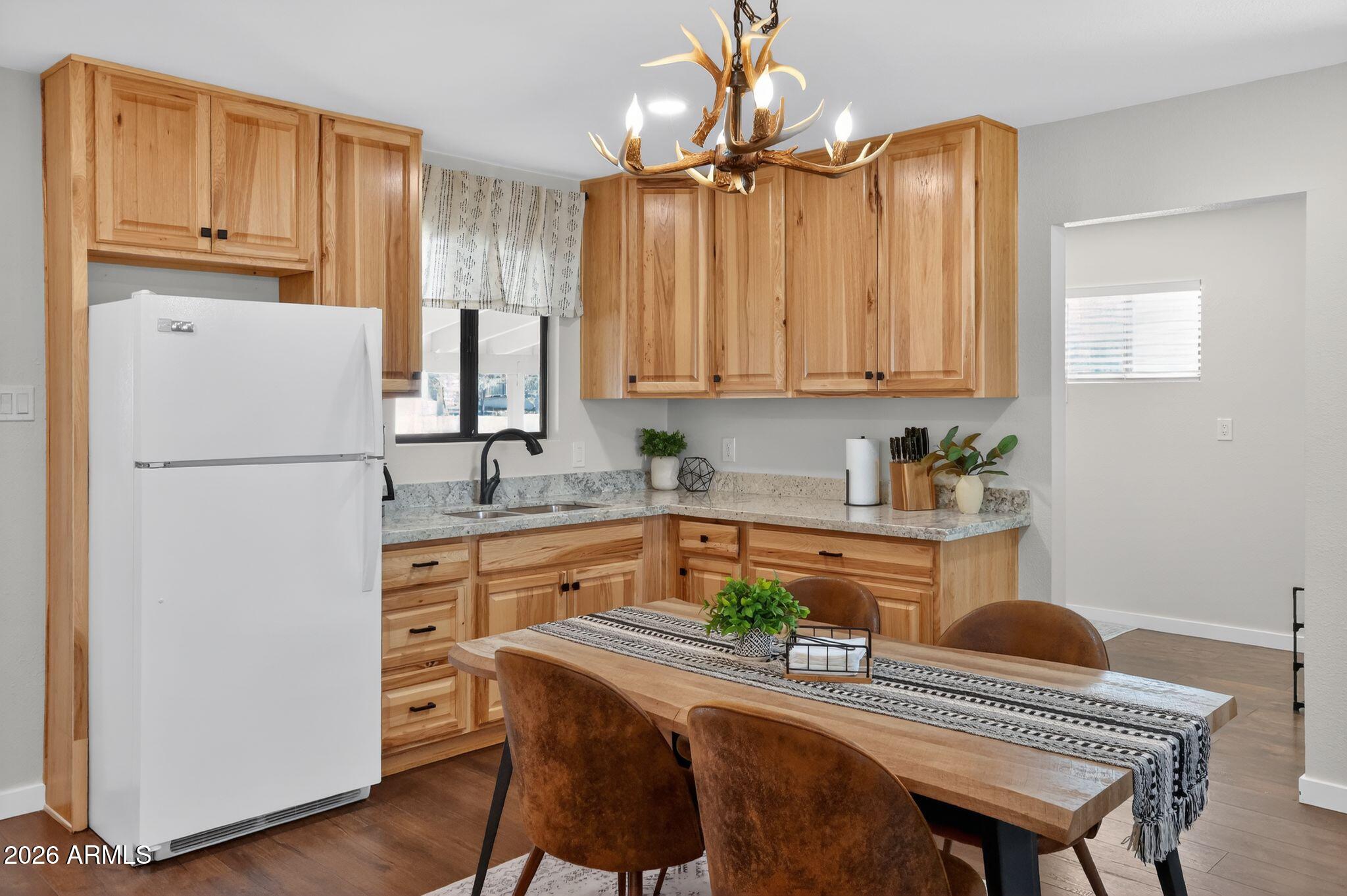 17160 Deer Run Road Munds Park, AZ 86017 - Photo 11 of 31 a kitchen with granite countertop a refrigerator a stove a sink dishwasher and white cabinets with wooden floor