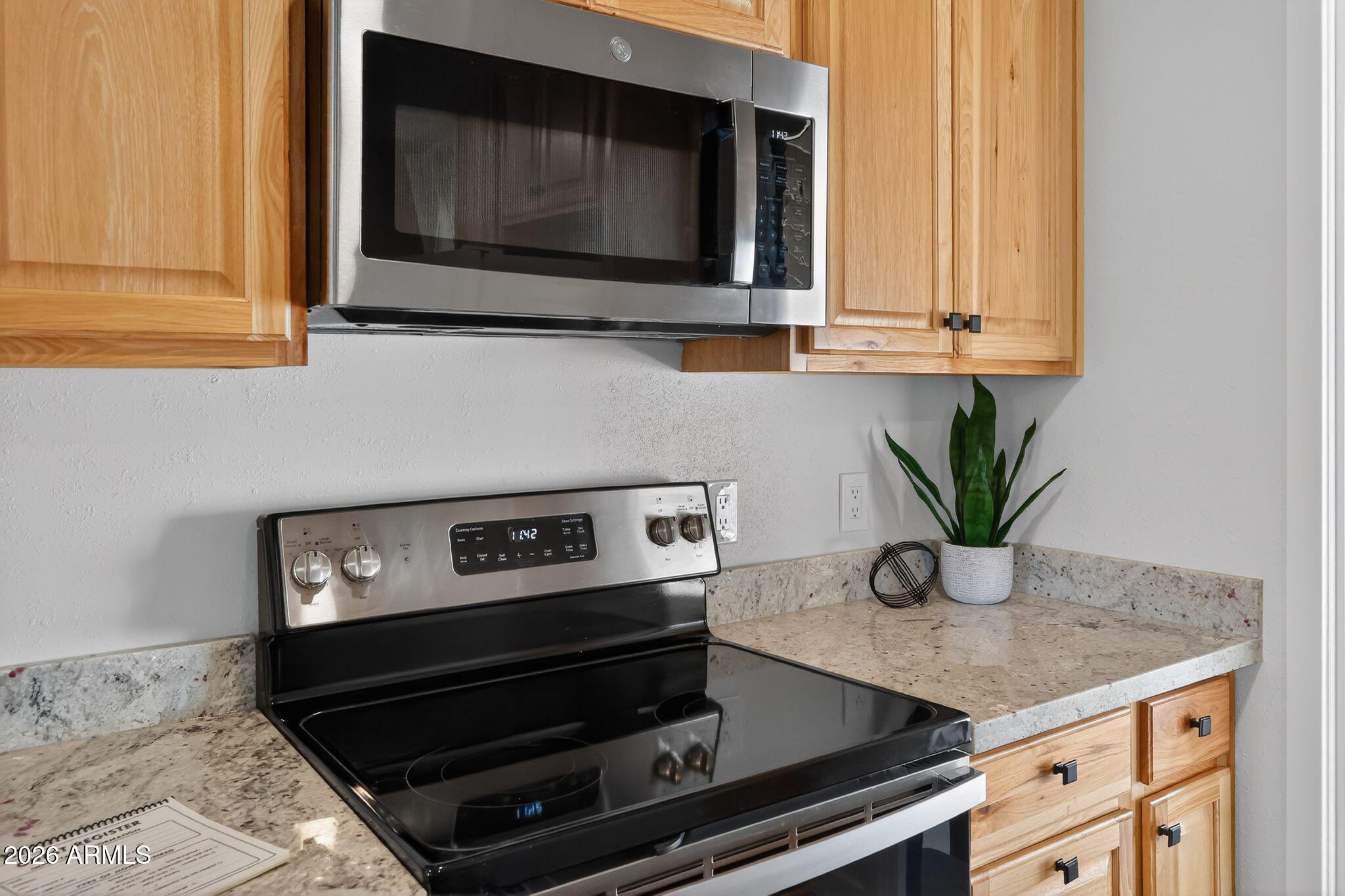 17160 Deer Run Road Munds Park, AZ 86017 - Photo 12 of 31 a kitchen with granite countertop a stove and a microwave