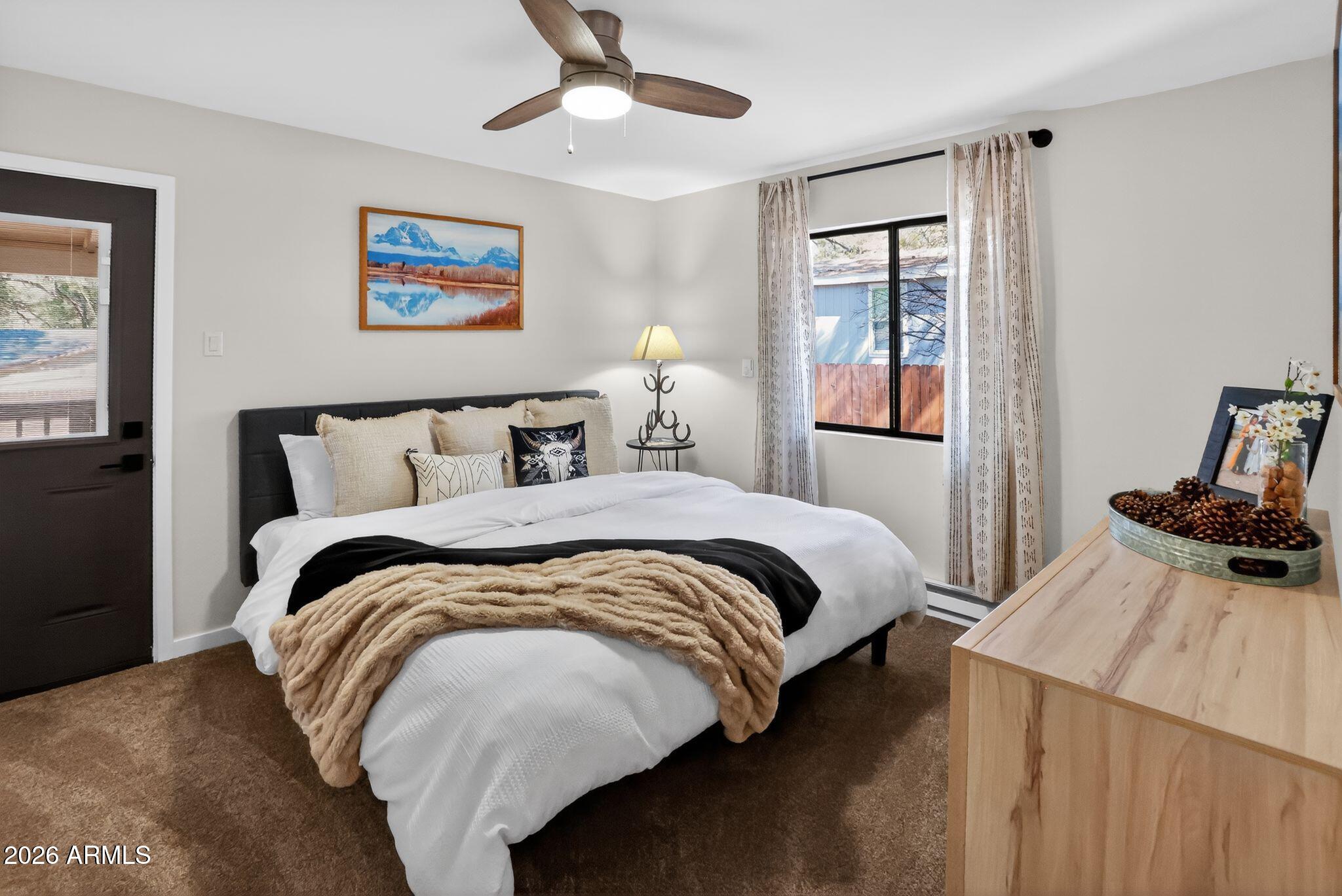 17160 Deer Run Road Munds Park, AZ 86017 - Photo 20 of 31 a bedroom with a bed and a chandelier