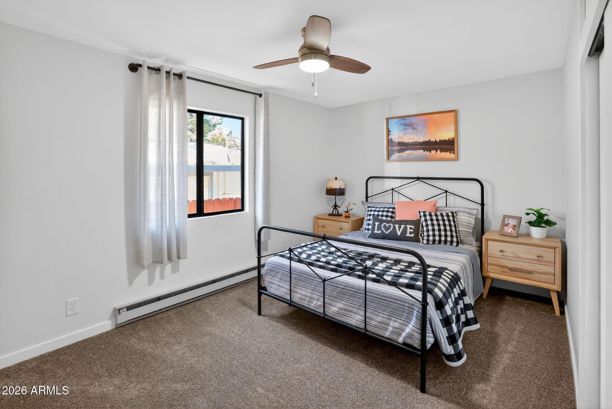 17160 Deer Run Road Munds Park, AZ 86017 - Photo 22 of 31 a bedroom with a bed and a chandelier