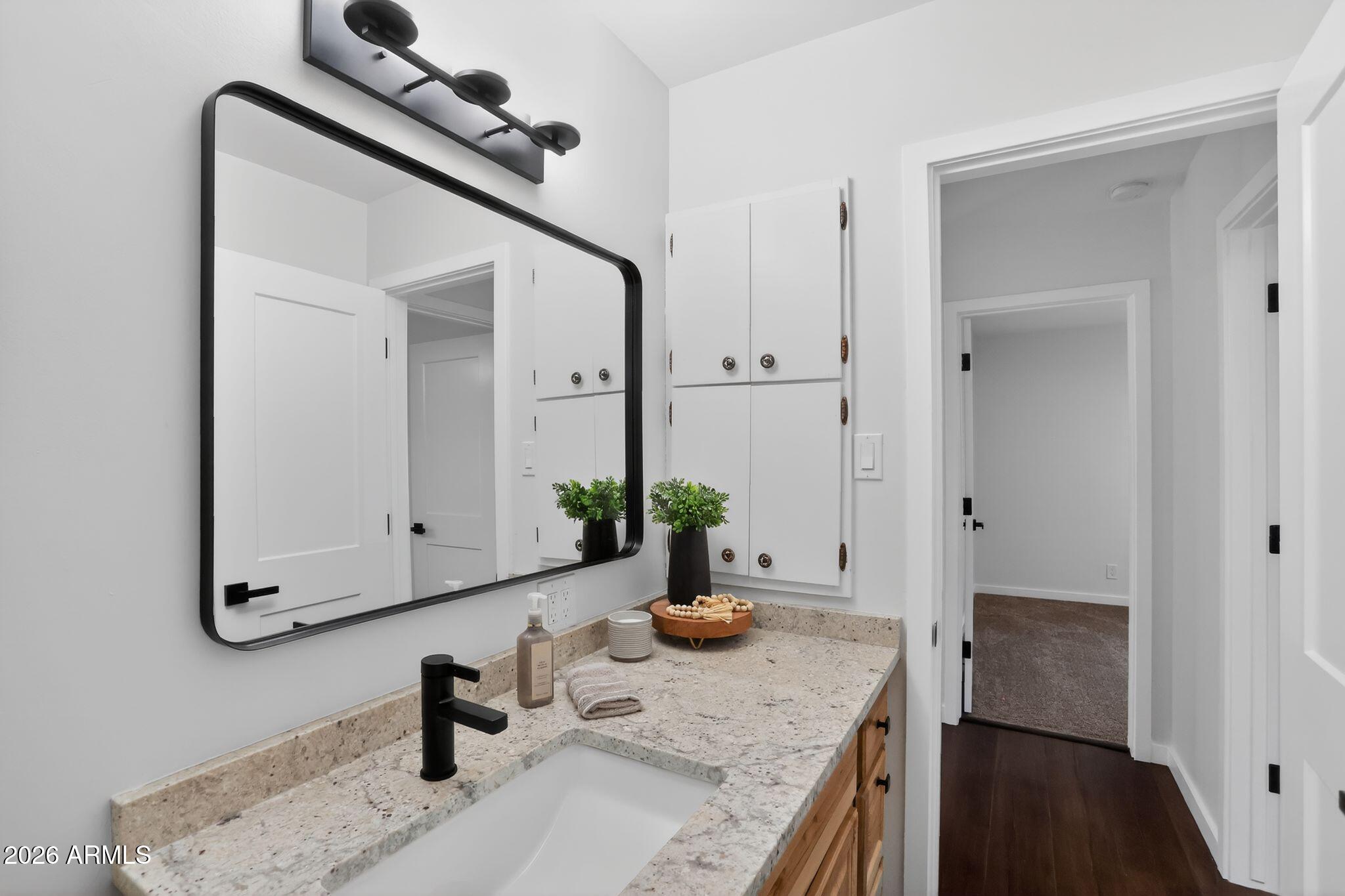 17160 Deer Run Road Munds Park, AZ 86017 - Photo 24 of 31 a bathroom with a granite countertop sink a mirror and vanity