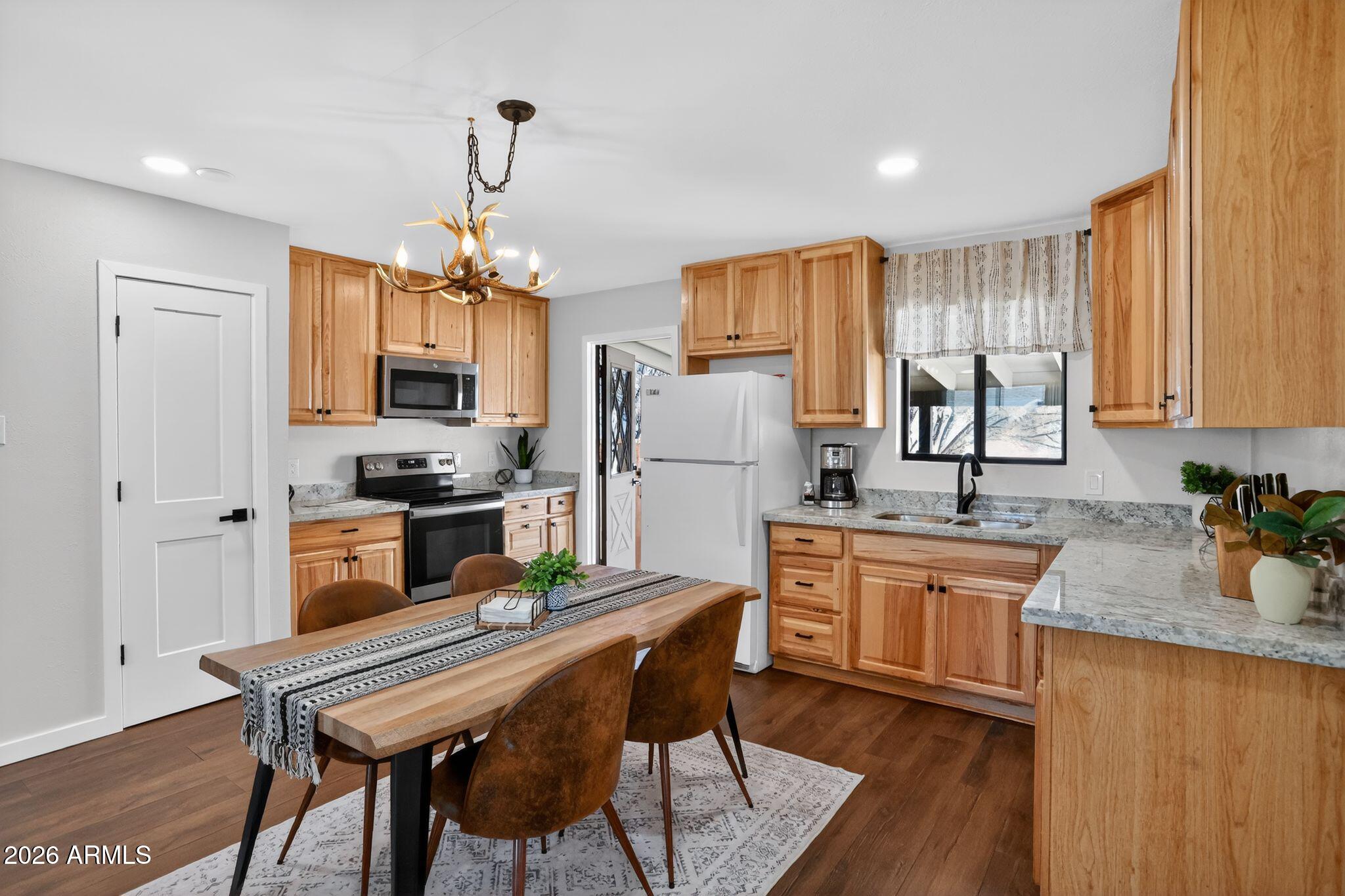 17160 Deer Run Road Munds Park, AZ 86017 - Photo 9 of 31 a kitchen with refrigerator a stove and wooden floor