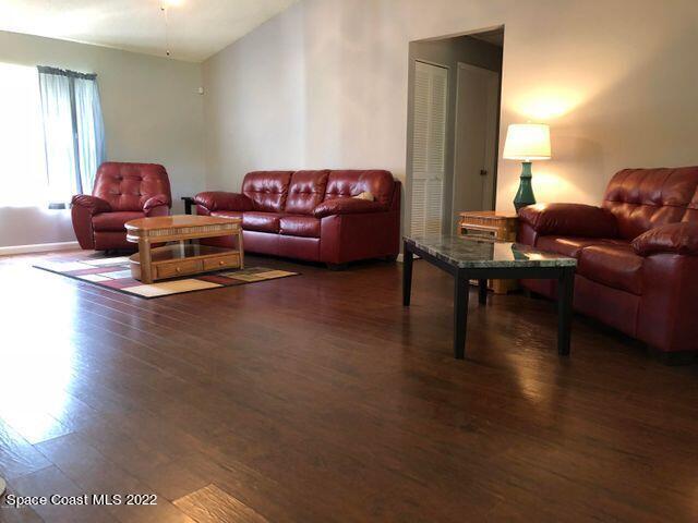 1324 Zanzibar Road Southeast Palm Bay, FL 32909 - Photo 8 of 18 a living room with furniture a flat screen tv and a wooden floor
