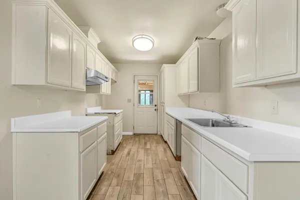 a kitchen with a sink a stove and cabinets