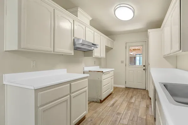 a kitchen with cabinets appliances and a wooden floor