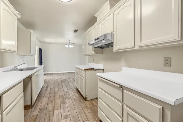 a kitchen with a sink a stove and cabinets