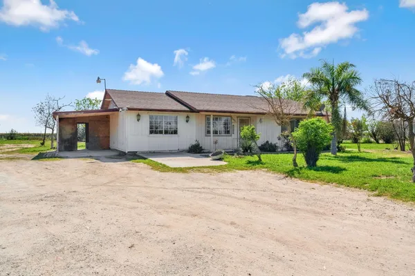 a view of an house with backyard and a tree