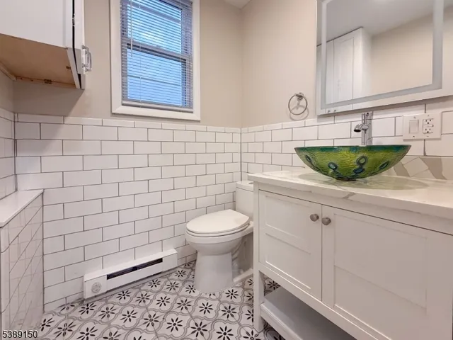 a bathroom with a granite countertop toilet and sink
