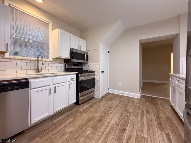 a kitchen with wooden floors and appliances