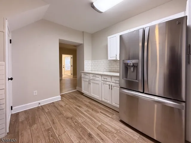a kitchen with granite countertop stainless steel appliances a refrigerator and cabinets