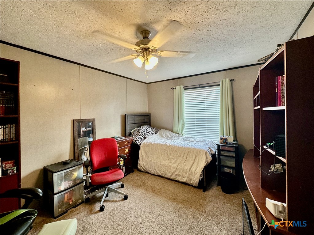 815 Track Road Dale, TX 78616 - Photo 17 of 21 a bedroom with a bed gym equipment and a chandelier