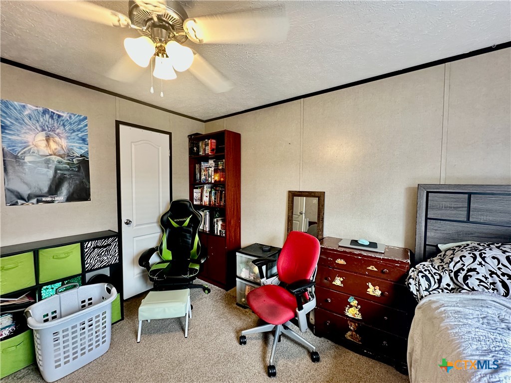 815 Track Road Dale, TX 78616 - Photo 18 of 21 a bedroom with a bed and a chandelier