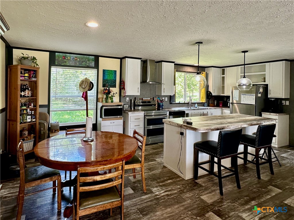 815 Track Road Dale, TX 78616 - Photo 4 of 21 a kitchen with stainless steel appliances kitchen island granite countertop a table chairs stove and refrigerator