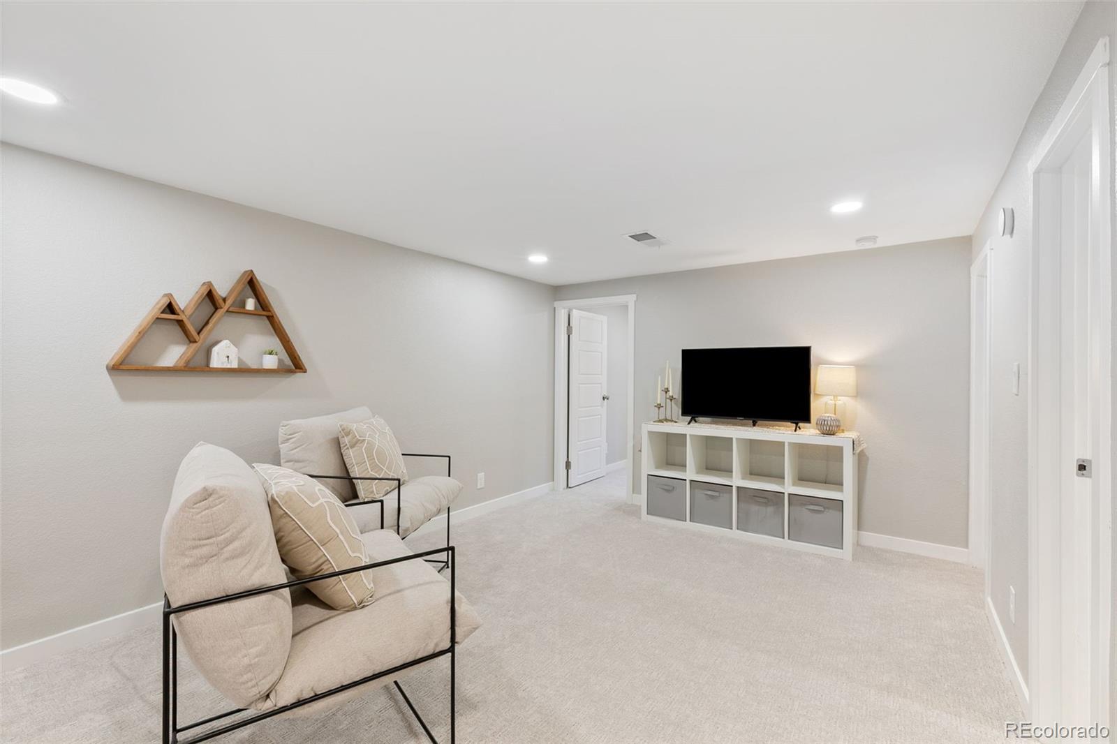 2023 Winston Road Colorado Springs, CO 80909 - Photo 20 of 39 a living room with furniture and a flat screen tv