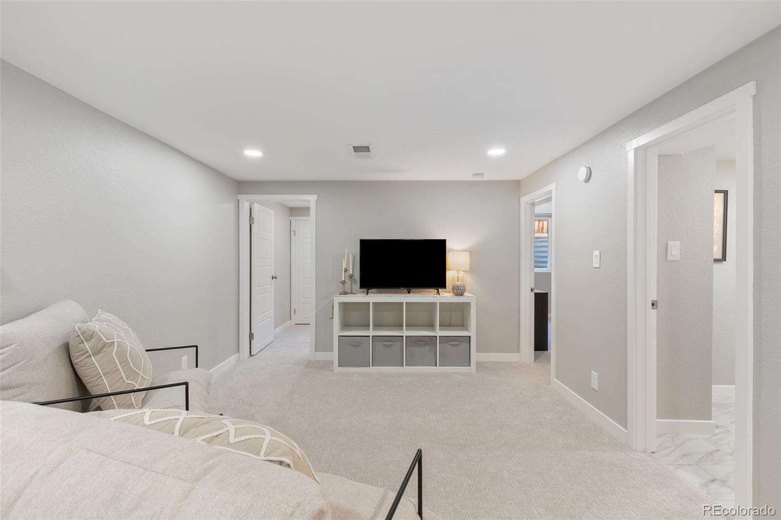 2023 Winston Road Colorado Springs, CO 80909 - Photo 21 of 39 a bed room with furniture and a flat screen tv