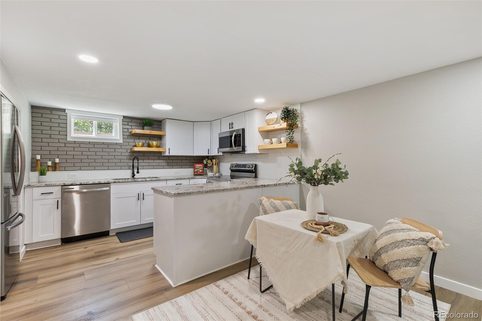 2023 Winston Road Colorado Springs, CO 80909 - Photo 26 of 39 a kitchen with granite countertop white cabinets stainless steel appliances and window