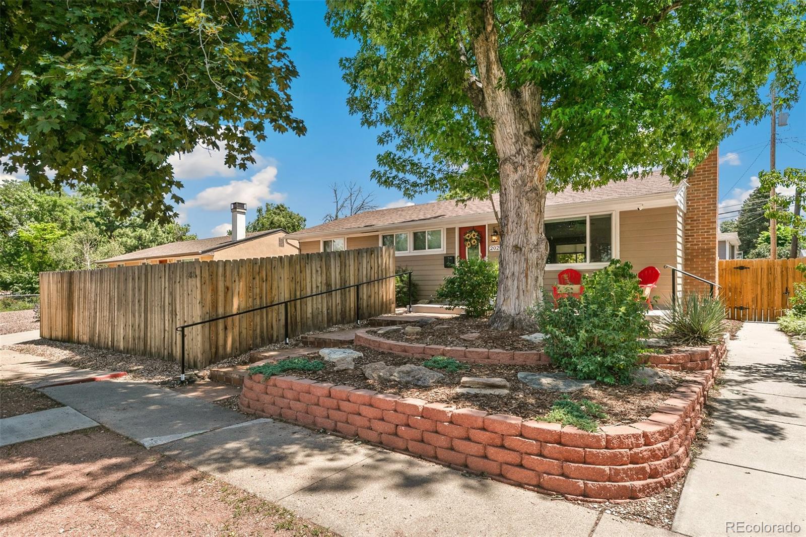 2023 Winston Road Colorado Springs, CO 80909 - Photo 32 of 39 a view of a backyard with plants and large tree