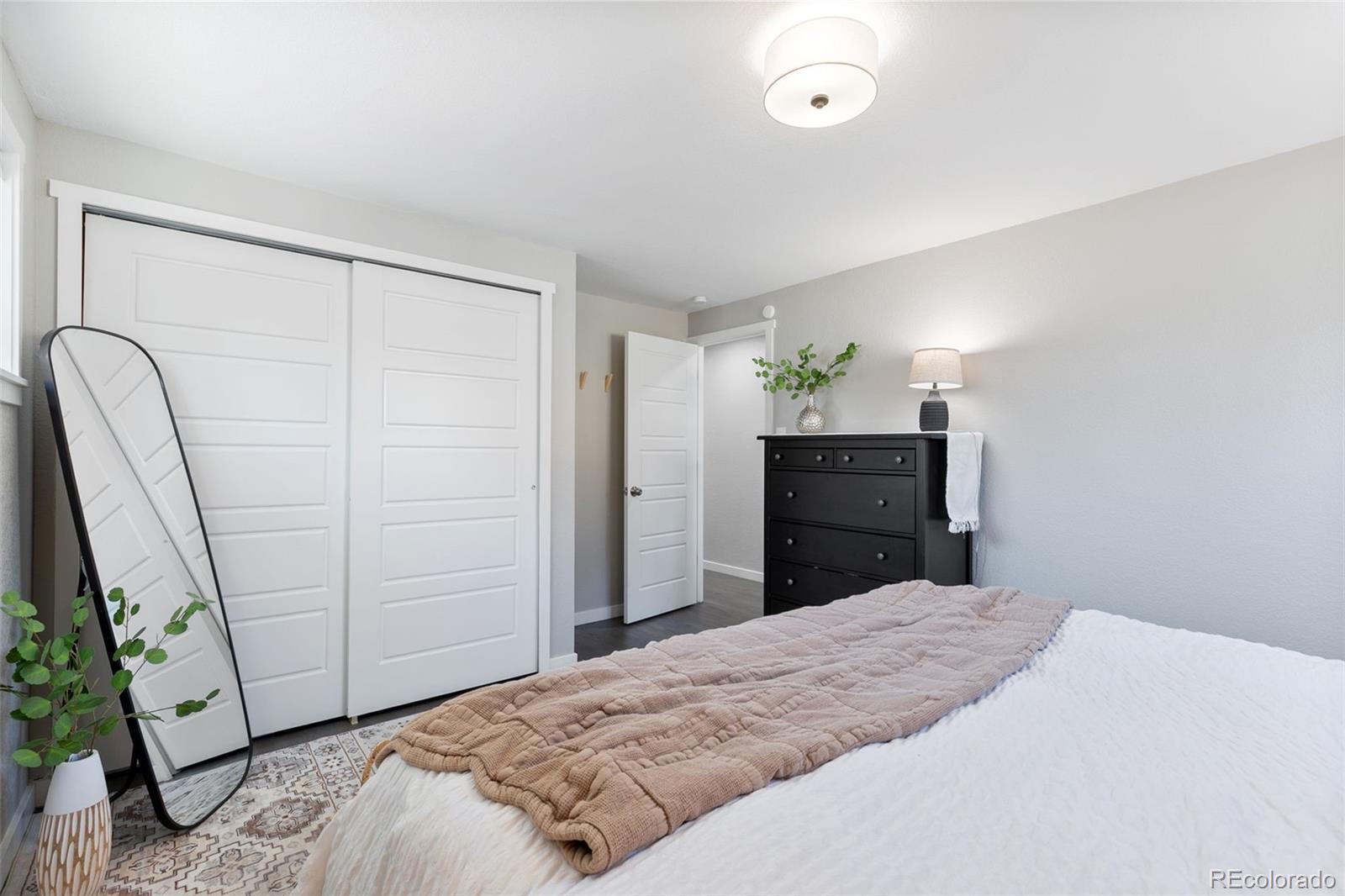 2023 Winston Road Colorado Springs, CO 80909 - Photo 8 of 39 a bedroom with a bed and a dresser