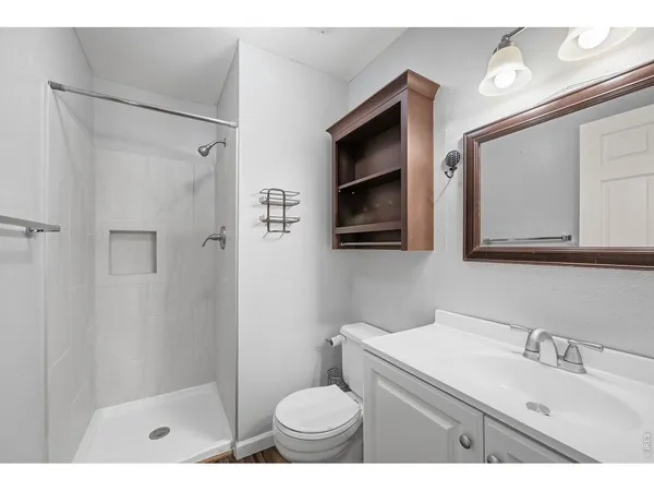 a bathroom with a sink a toilet a shower and a mirror