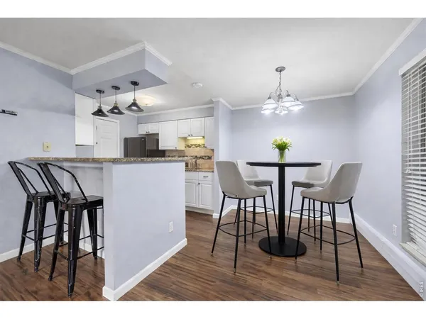 a kitchen with stainless steel appliances kitchen island granite countertop a table chairs and a chandelier