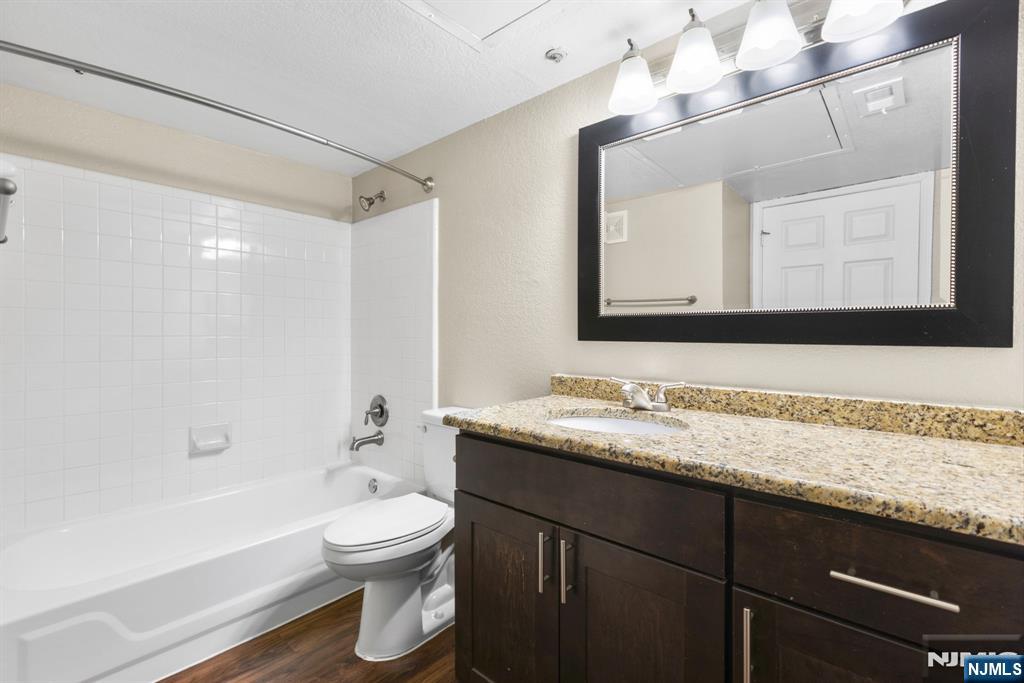 690 Rt 23, Unit 1349 Wayne, NJ 07470 - Photo 8 of 11 a bathroom with a granite countertop sink toilet a large mirror a bathtub and shower