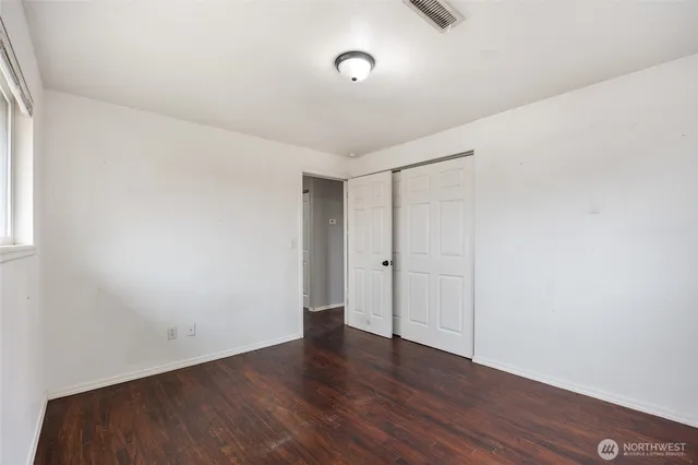 a view of an empty room with wooden floor