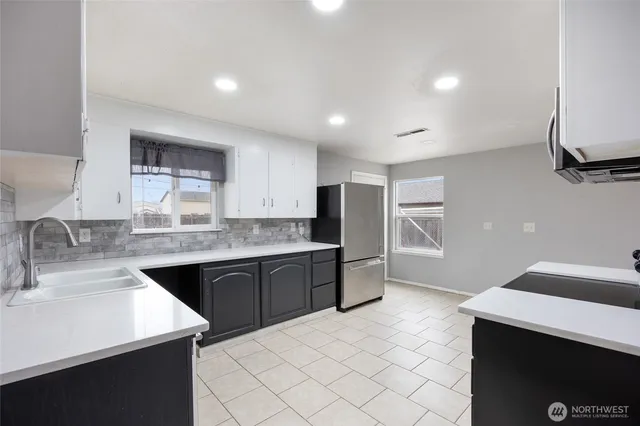 a kitchen with stainless steel appliances a sink stove and refrigerator