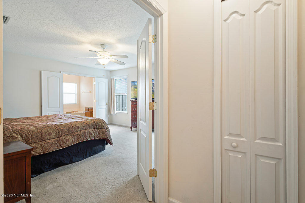 2443 Paris Mill Road Jacksonville, FL 32221 - Photo 17 of 33 a spacious bedroom with a bed and a chandelier