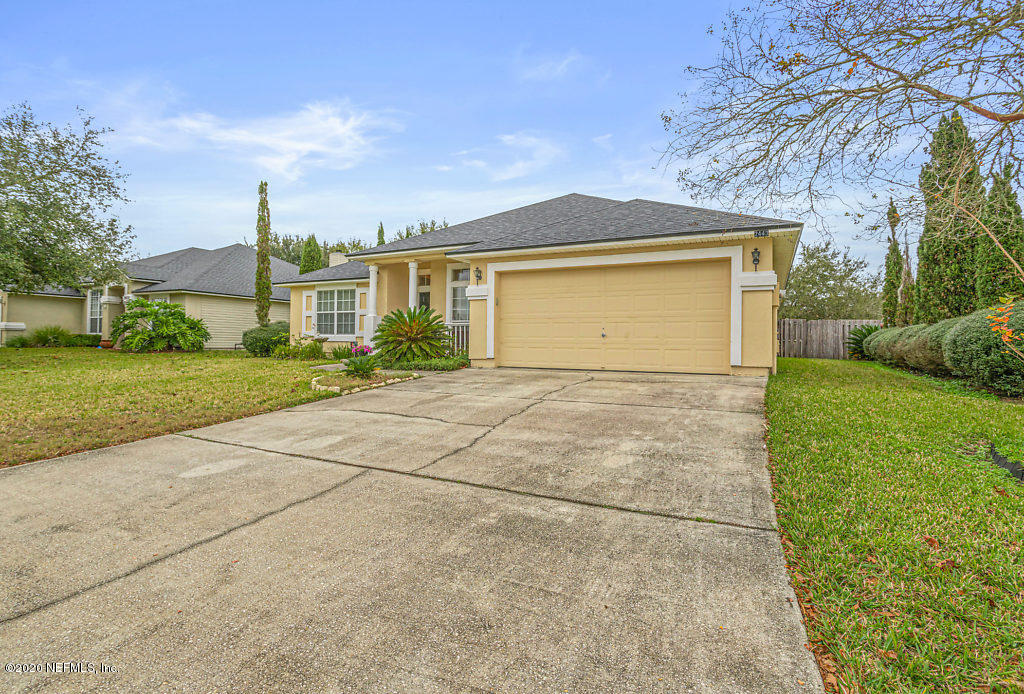 2443 Paris Mill Road Jacksonville, FL 32221 - Photo 3 of 33 a front view of a house with a yard and garage