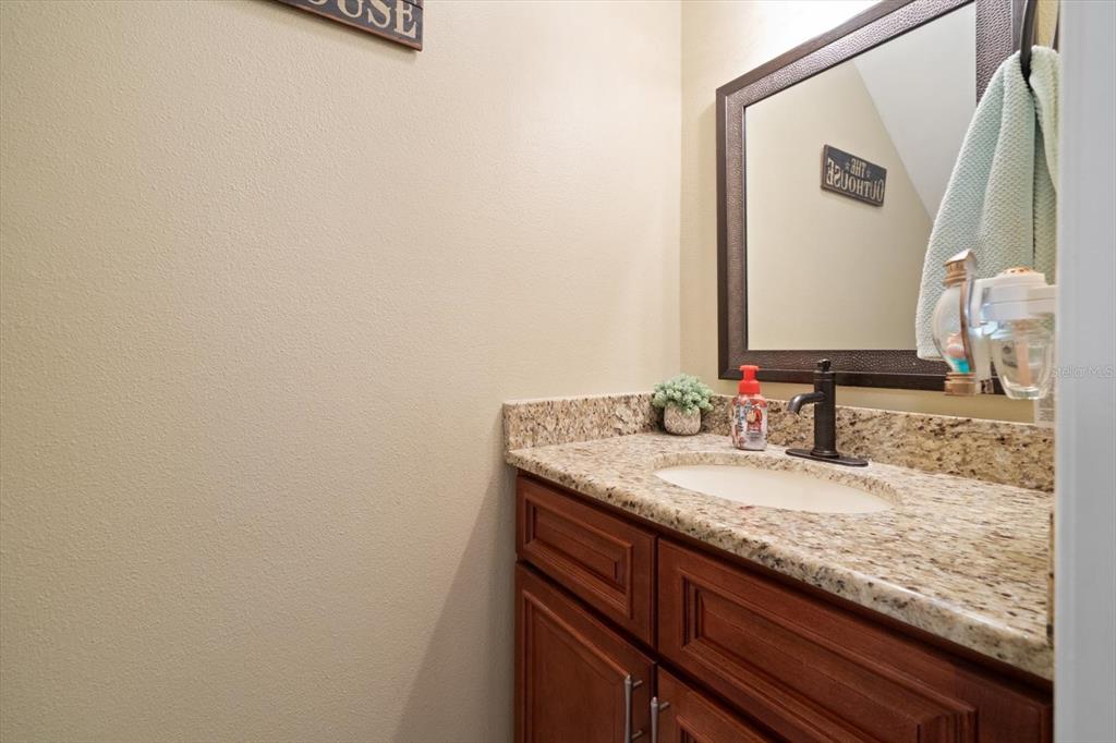 2131 Ridge Road South, Unit 75 Largo, FL 33778 - Photo 11 of 32 a bathroom with a granite countertop sink and a mirror