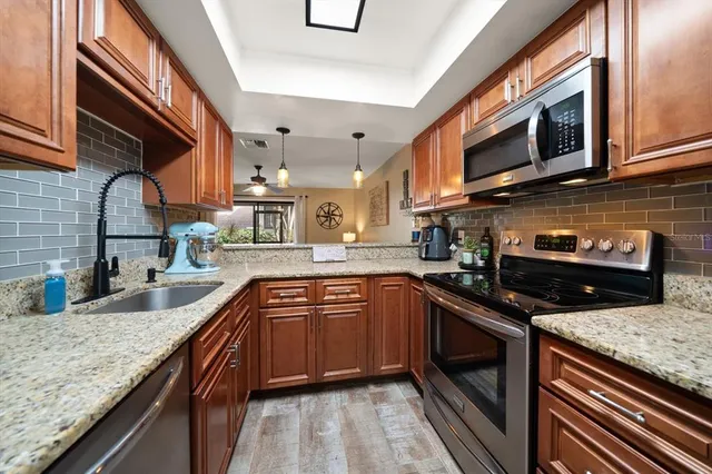 a kitchen with stainless steel appliances granite countertop a sink and stove