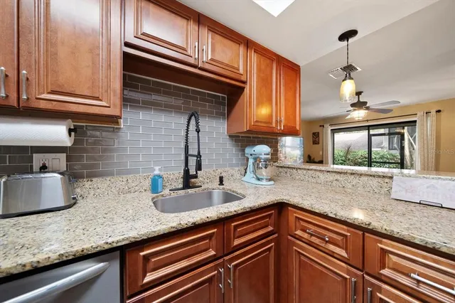 a kitchen with granite countertop stainless steel appliances a sink and cabinets