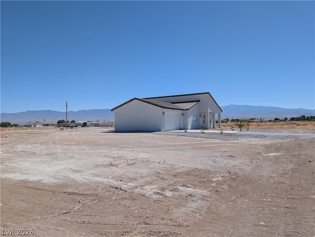 4670 Medicine Man Road Pahrump, NV 89048 - Photo 31 of 36 Discover a new construction home set against a mountain backdrop, ready for your personalized landscaping touches.